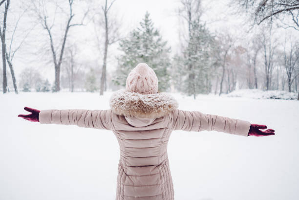 istock Woman spreading hands in a snow covered park 1057237830