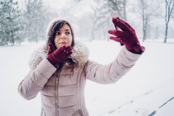 istock woman taking selfies in the snow 1057237920