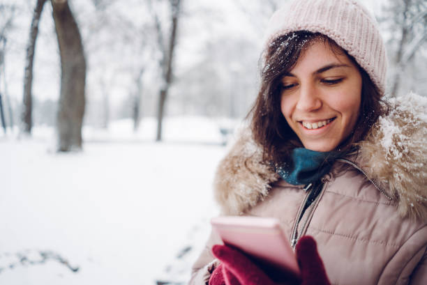 istock woman using phone in the snow 1057238142