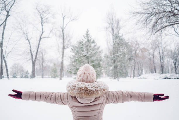 istock Woman spreading hands in a snow covered park 1057238320