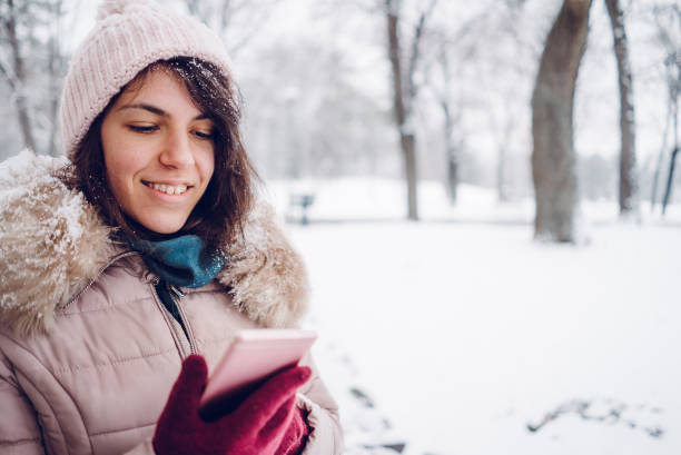 istock woman using phone in the snow 1057238464
