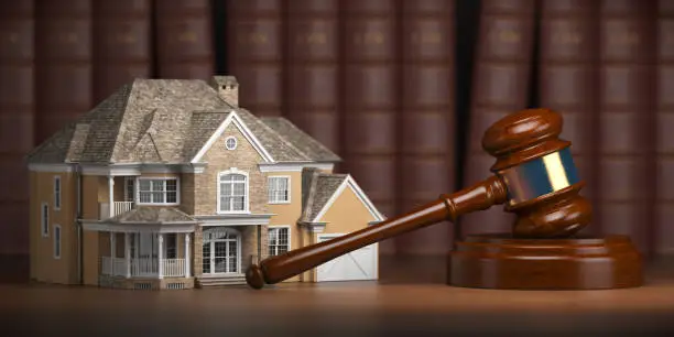 Photo of House with gavel and law books.  Real estate law and house auction concept