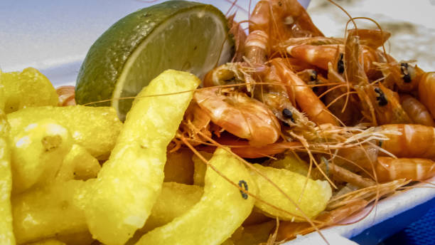 istock Appetizer potato chips with shrimp, served on the beach 1057243438