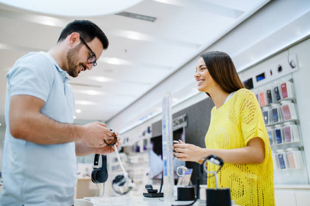 istock Happy couple holding smart watches while standing in tech store. 1057248544