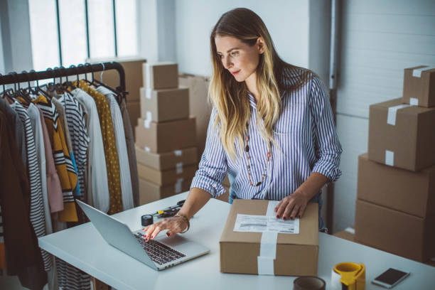 Small business owener Women, owener of small business packing product in boxes, preparing it for delivery. small business owner stock pictures, royalty-free photos & images
