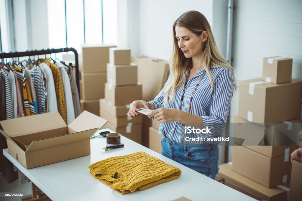 Small business owener Women, owener of small business packing product in boxes, preparing it for delivery. Photographing Stock Photo