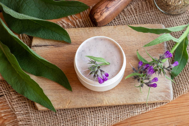 istock A jar of homemade comfrey root ointment with fresh blooming comfrey 1057259064