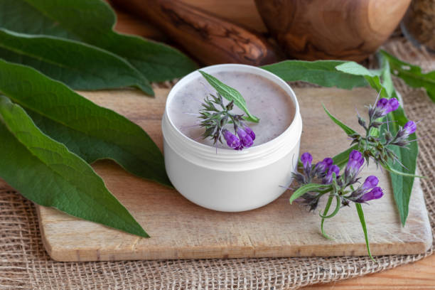 istock A jar of homemade comfrey root ointment with fresh blooming comfrey 1057259090