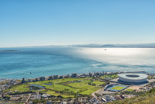 An aerial view of Green Point in Cape Town as seen from Signal Hill. The Cape Town Stadium and other sport facilities are visible. Robben Island is visible