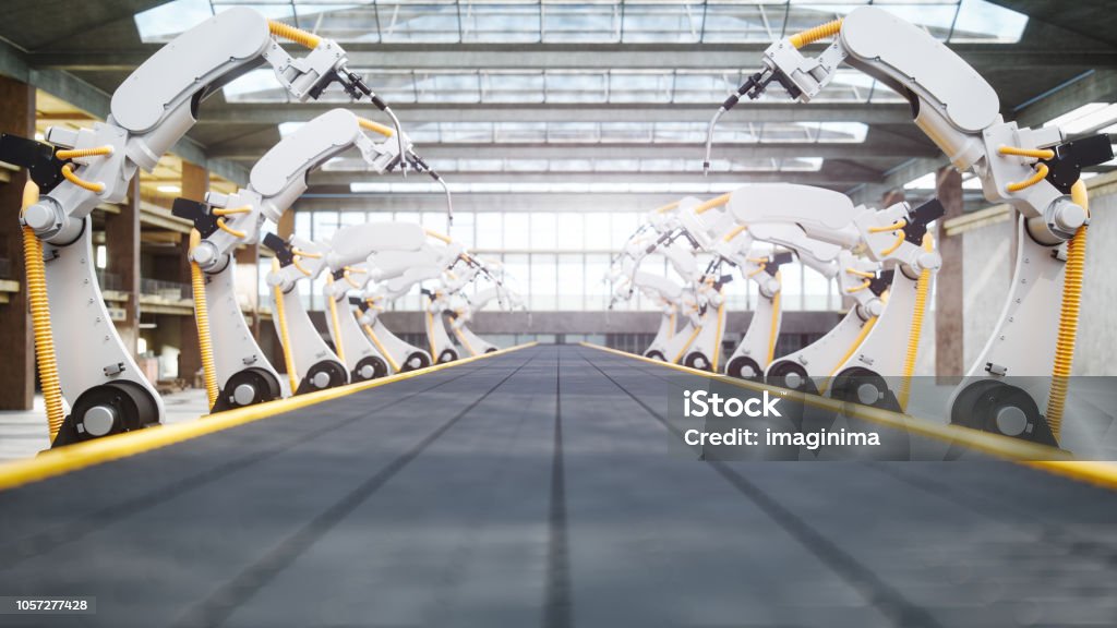 Welding Robots And Conveyor Belt In Automated Factory Interior of a modern automated factory with robotic arms and conveyor belt. Factory Stock Photo
