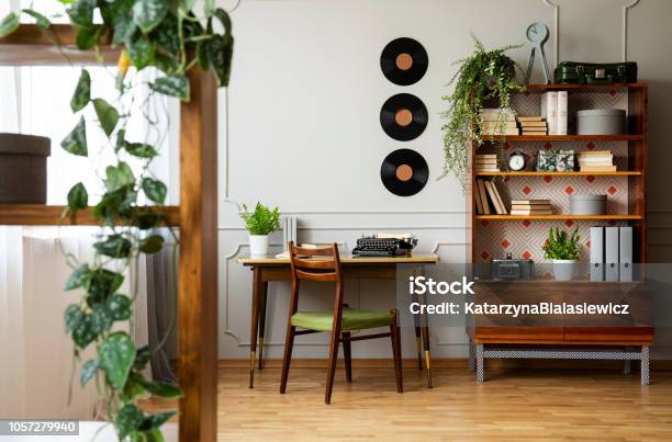 Black Retro Typewriter On A Unique Wooden Desk A Midcentury Modern Chair And A Renovated Bookcase In A Hipster Home Office Interior Real Photo Stock Photo - Download Image Now