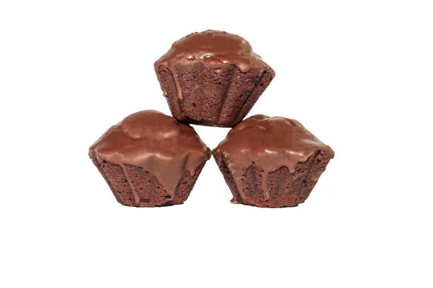 istock Single chocolate black cupcake coated in chocolate whit birthday candle isolated on white background from above 1057280396