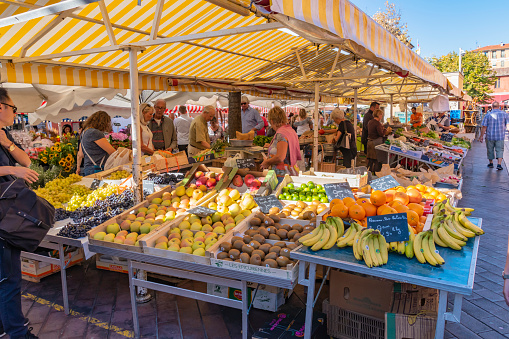 Nice, France - October 5, 2018: View of a market in Nice with different market stalls and customers.
