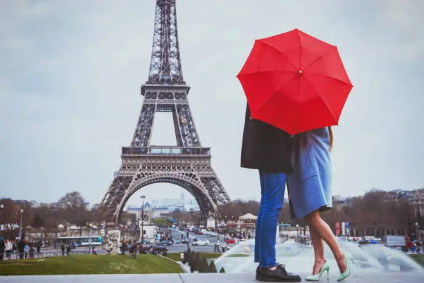 Photo of Rmantic couple in Paris kissing near Eiffel towe.