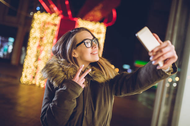 istock Woman making selfies downtown at night 1057290818