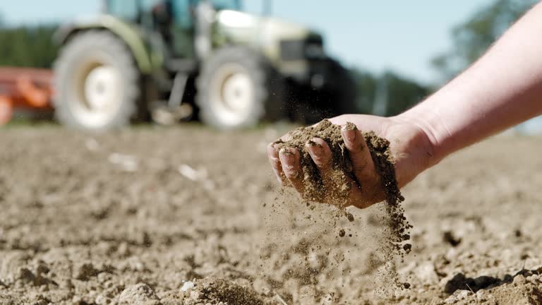 SLO MO Farmer's hand scooping dirt on a field