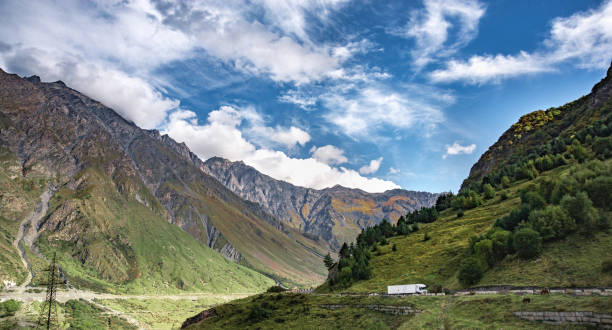 istock Mountain hill path road panoramic landscape, clouds in the blue sky 1057295514
