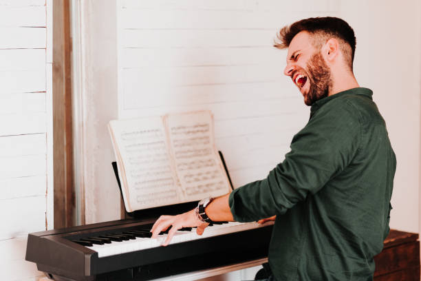 istock Young man playing electric piano at home 1057297160