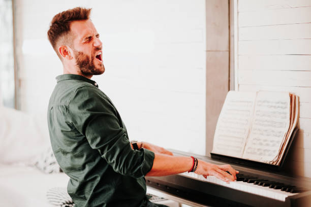 istock Young man playing electric piano at home 1057297162