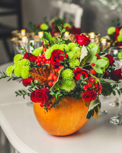 istock Fresh flowers, leaves, tools and pumpkin. florist's. close-up partial view 1057300924