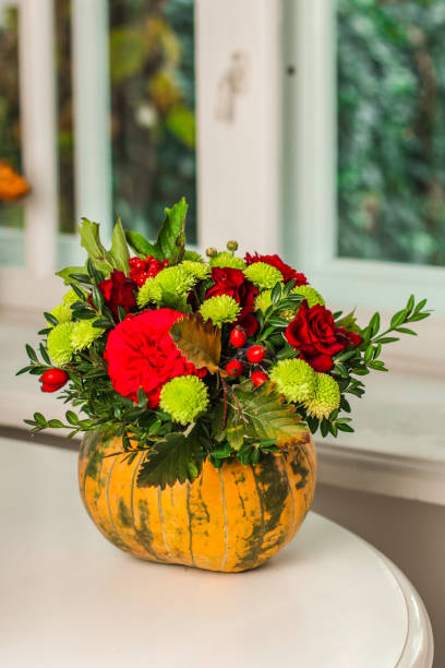 istock Fresh flowers, leaves, tools and pumpkin. florist's. close-up partial view 1057300926