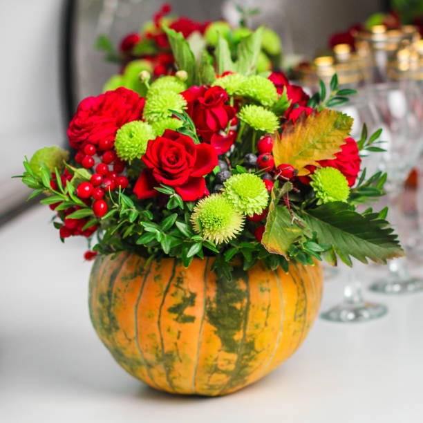 istock Fresh flowers, leaves, tools and pumpkin. florist's. close-up partial view 1057300932
