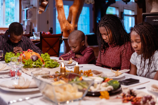 cena de acción de gracias con americano africano familia orando - family thanksgiving dinner praying fotografías e imágenes de stock
