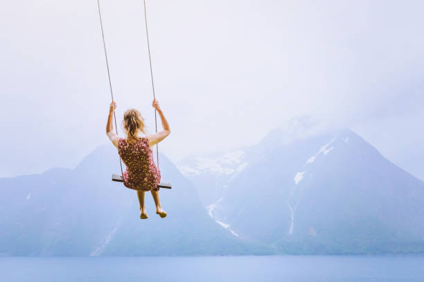koncepcja szczęścia, szczęśliwa dziewczyna dziecka na huśtawce na pięknym górskim krajobrazie - sky high zdjęcia i obrazy z banku zdjęć