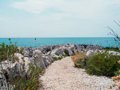 Pathway leading towards the mediterranen, with white rocks and blue sky