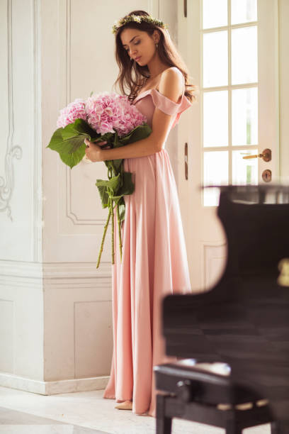 beautiful woman with hydrangeas in arms standing in nice palace's interior. - bride wedding fashion evening gown imagens e fotografias de stock