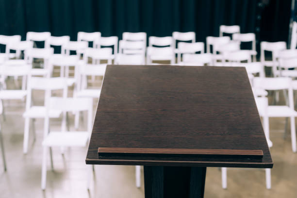 istock podium tribune and empty white chairs in conference hall 1057326602