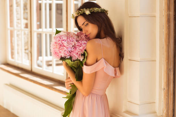 istock Beautiful woman holding a pink hydrangeas in her arms. 1057326656
