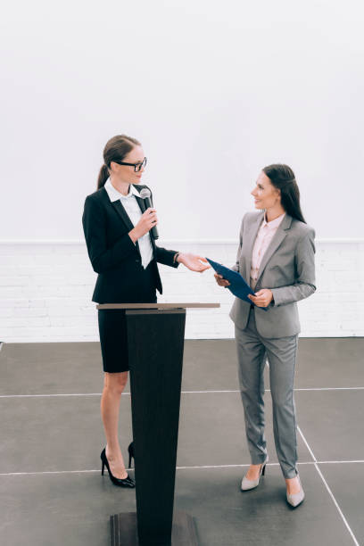 istock high angle view of attractive lecturer looking at smiling assistant during seminar in conference hall 1057329990
