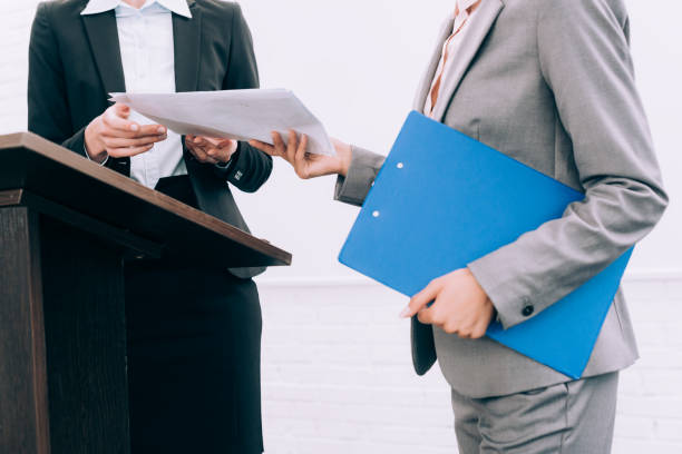 istock cropped image of assistant giving documents to speaker during seminar in conference hall 1057330000