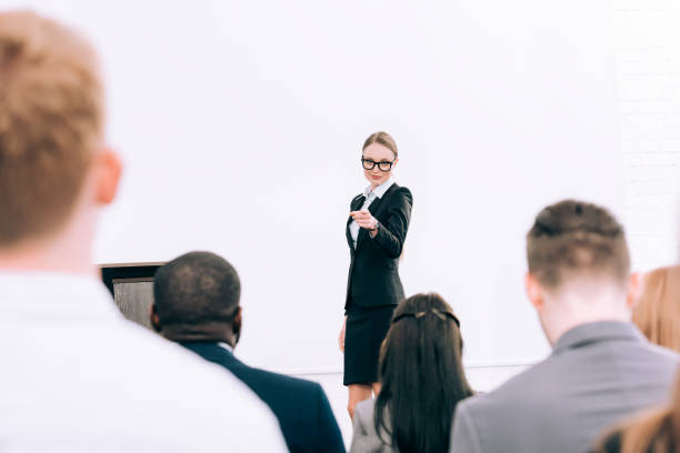 istock attractive lecturer pointing on multicultural audience during seminar in conference hall 1057330134
