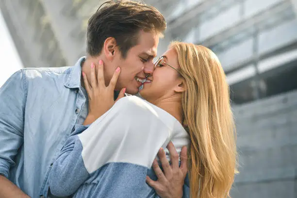 Photo of Young couple smiling and having fun outdoors on a date.