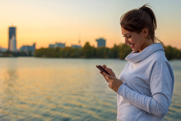istock Beautiful young woman sending a text message on her smartphone outside 1057336892