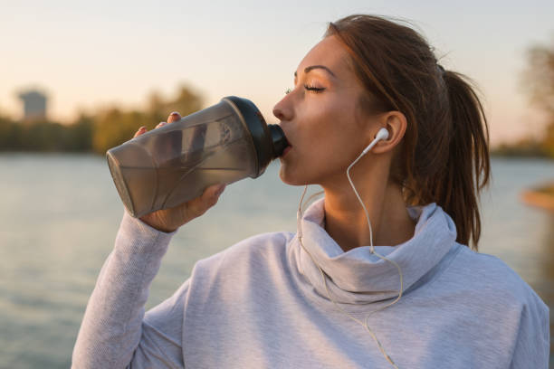 istock Beautiful young woman drinking water after workout outside 1057337178