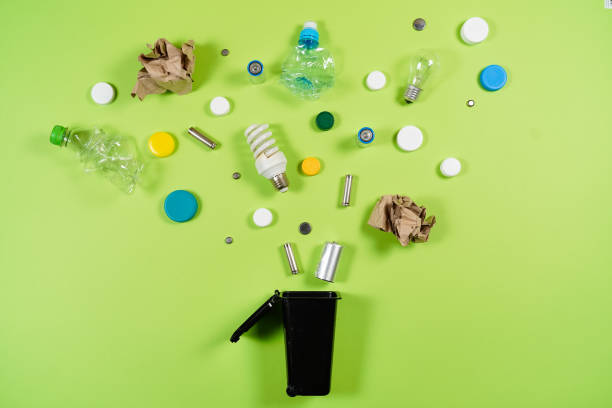 istock Trash bins and assorted garbage isolated on green, recycle concept 1057338310