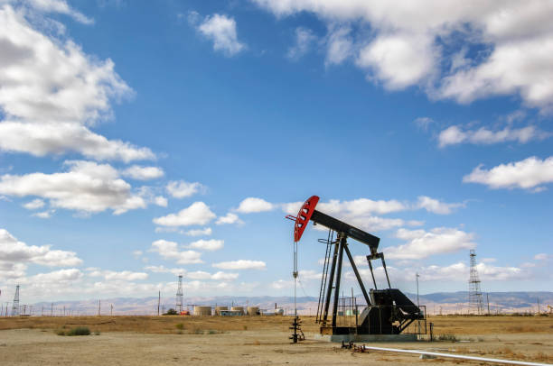 istock Oil Pumpjack with Electrical Pylons in Background 1057340084