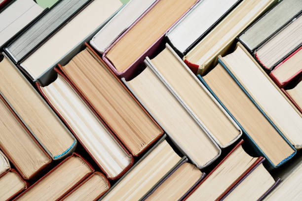 istock Many Books Piles. Hardback books on wooden table. 1057342572