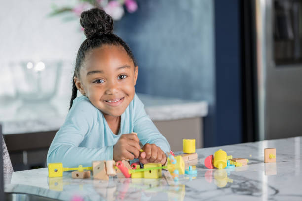 istock Elementary girl using STEM educational toys at home 1057343944