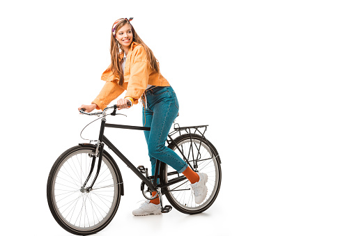 smiling beautiful hipster girl sitting on bicycle isolated on white