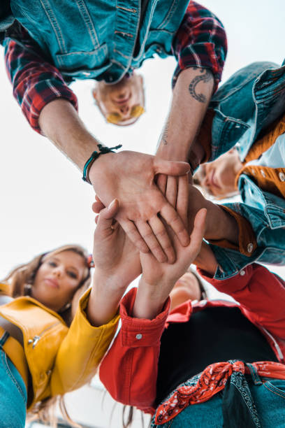istock bottom view of team of students holding hands together 1057362826
