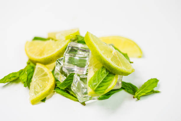 istock Ice with mint on light background. Ice cubes and mint leaves isolated on blue background 1057365516