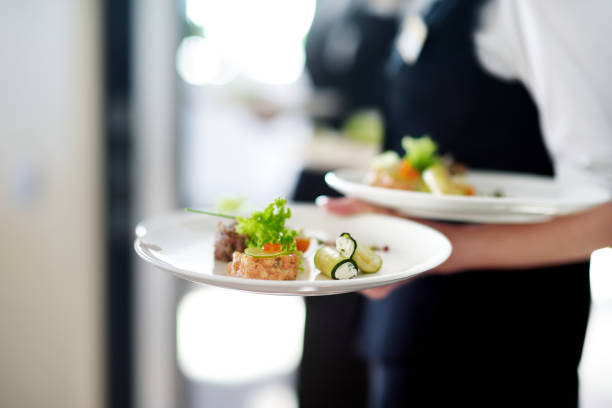 istock Waiter carrying plates with meat dish 1057369186