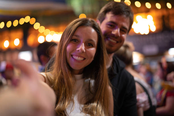 istock Young Couple Taking a Selfie at Party 1057375622