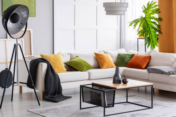 istock Lamp next to white corner settee with cushions in bright apartment interior with table. Real photo 1057384626