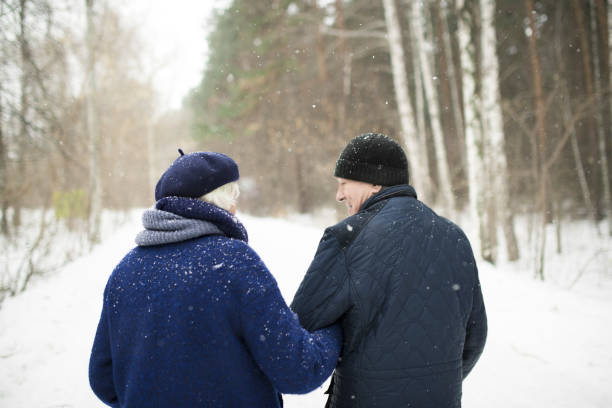 istock Senior Couple in Winter Forest Back View 1057387890