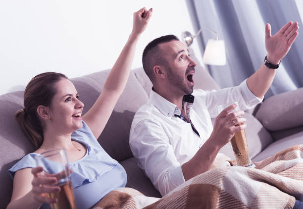 istock Couple is watching football on the sofa 1057389626